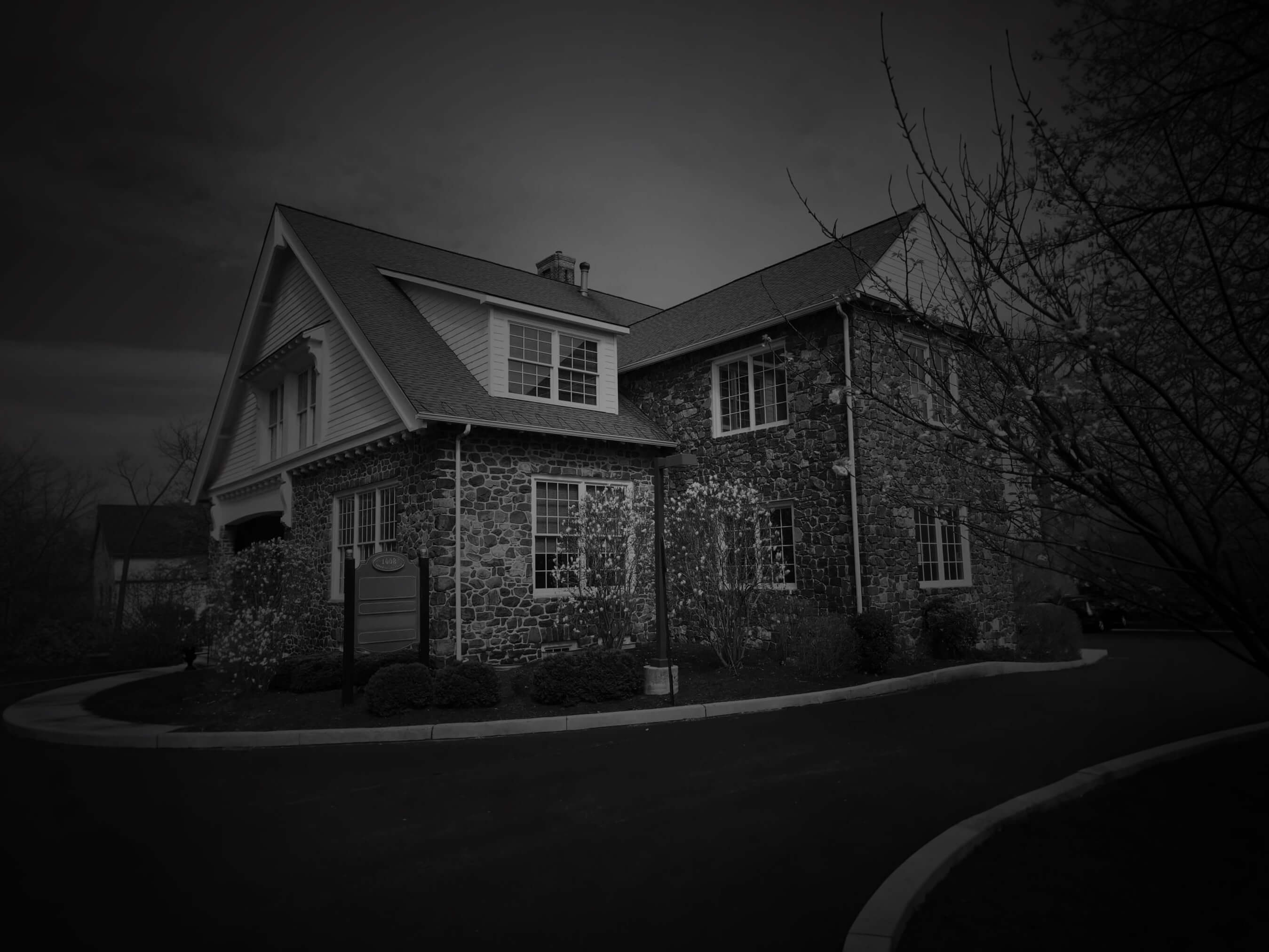 The building at 1008 Upper Gulph Road: two stories of fieldstone with white trim and a slate roof, set behind a curved drive.